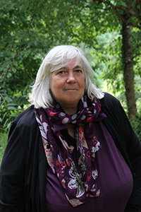 Mary stands in front of trees